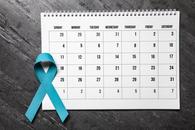 Flat lay composition with teal ribbon and calendar on grey background