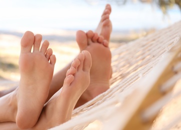 Couple relaxing in hammock on beach, closeup. Summer vacation