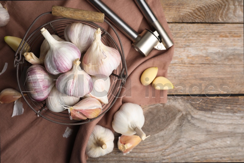 Fresh organic garlic on wooden table, flat lay. Space for text