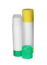 Different glue sticks and cap on white background