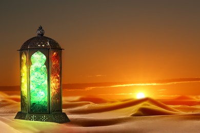 Beautiful Arabic lantern on sand at sunset, space for text