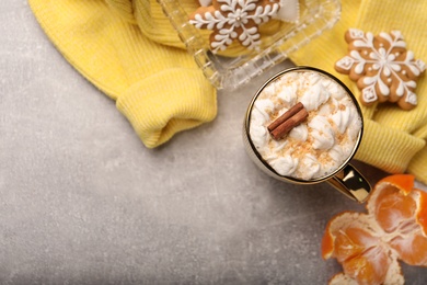 Photo of Flat lay composition with delicious marshmallow drink and yellow sweater on light grey table. Space for text
