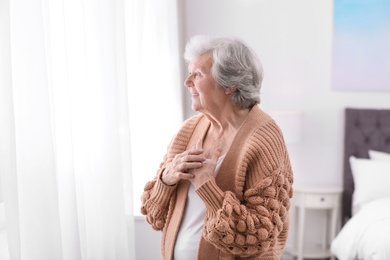Portrait of beautiful grandmother in sweater at home
