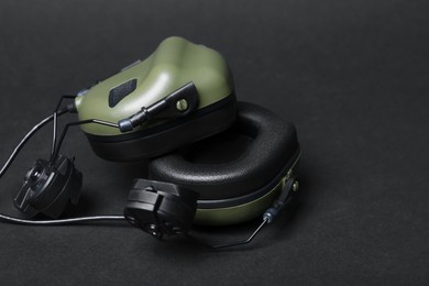 Photo of Tactical headphones on black background, closeup. Military training equipment