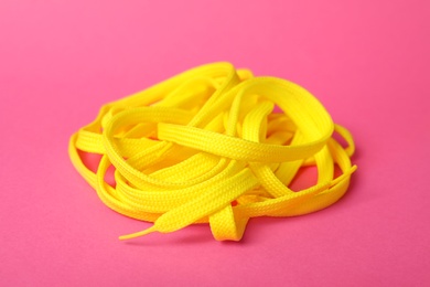 Yellow shoe lace on pink background. Stylish accessory