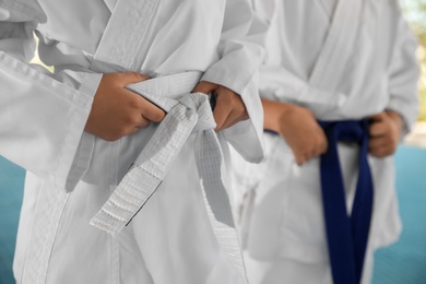 Photo of Children in kimono during karate practice on tatami, closeup