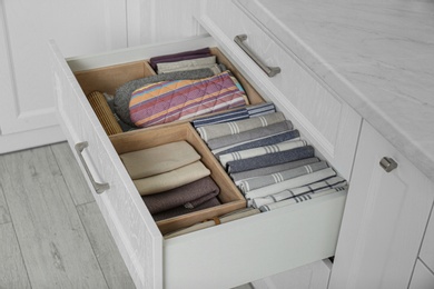 Open drawer with different textiles in kitchen
