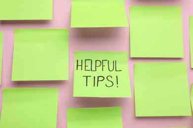 Photo of Paper note with phrase Helpful Tips on pink background