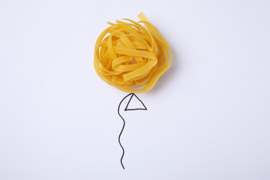 Balloon made with tagliatelle pasta on white background, top view