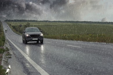 View of country road with car on rainy day