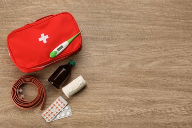 First aid kit on wooden table, flat lay. Space for text