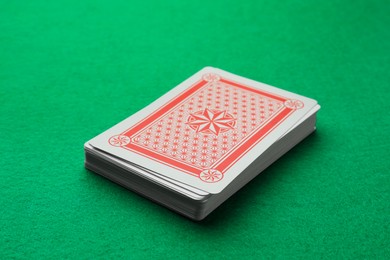 Deck of playing cards on green table, closeup. Poker game