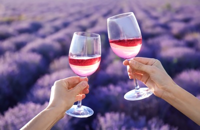 People with glasses of wine in lavender field