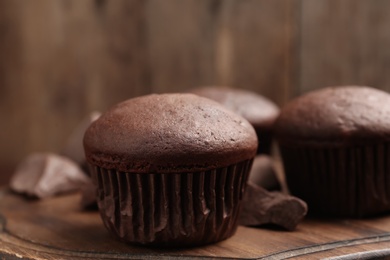 Delicious chocolate cupcake on wooden board, closeup