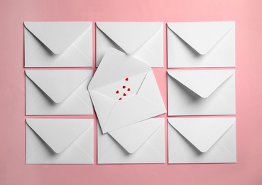 Envelopes and heart shaped sprinkles on pink background, flat lay. Love letters