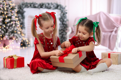 Cute little children with Christmas gifts at home
