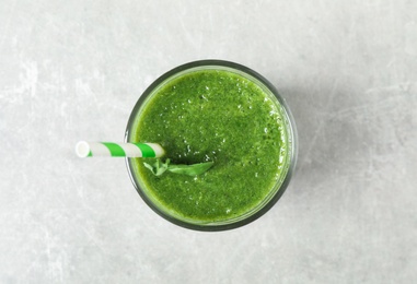 Fresh green juice on light grey table, top view