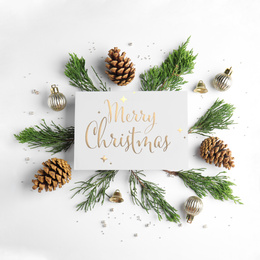 Flat lay composition with text MERRY CHRISTMAS and festive decor on white background