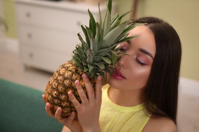 Young woman with fresh pineapple at home. Exotic fruit