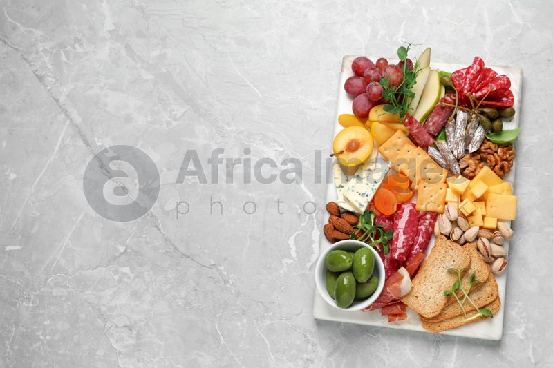 Different tasty appetizers on light marble table, top view. Space for text