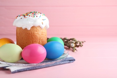 Traditional Easter cake, colorful eggs and willow branches on pink background. Space for text