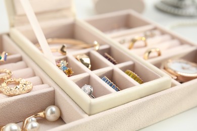 Jewelry box with stylish golden bijouterie on white table, closeup