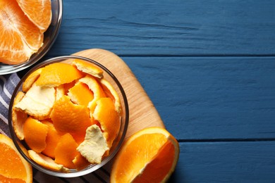 Photo of Orange peels preparing for drying and fresh fruits on blue wooden table, flat lay. Space for text