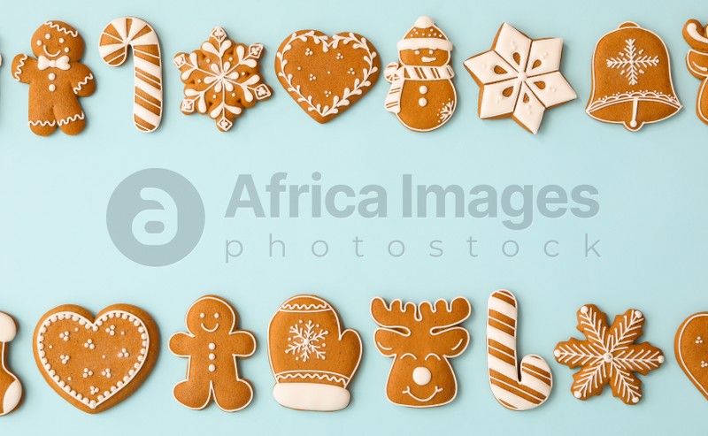 Different Christmas gingerbread cookies on light blue background, flat lay. Space for text