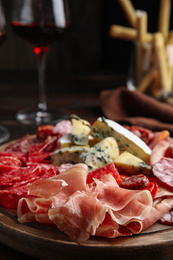 Photo of Tasty prosciutto with other delicacies served on table