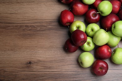 Photo of Fresh ripe red and green apples on wooden table, flat lay. Space for text