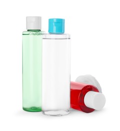 Bottles of micellar cleansing water and cotton pads on white background