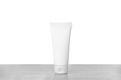 Tube of hand cream on gray table against white background