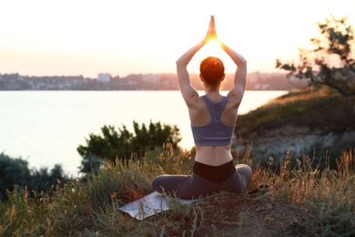 Young woman practicing yoga outdoors on sunset. Zen meditation