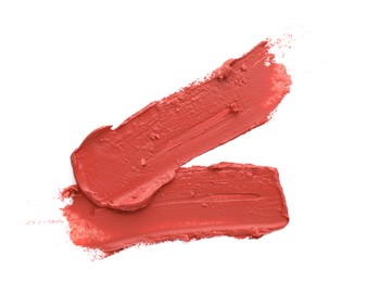 Smears of coral lipstick on white background
