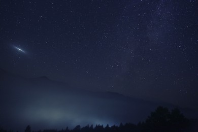 Picturesque view of night sky with beautiful stars over foggy hill
