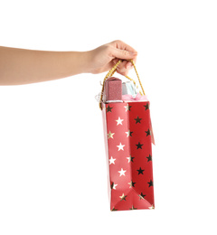 Woman holding shopping paper bag with presents on white background, closeup