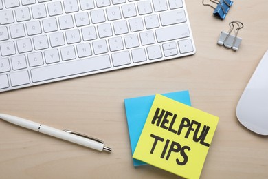 Helpful Tips. Computer keyboard, mouse and stationery on wooden table, flat lay
