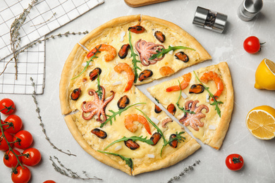 Delicious seafood pizza on grey marble table, flat lay