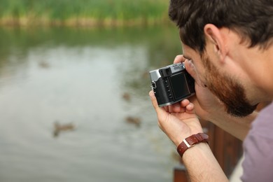 Photo of Man with camera taking photo outdoors, space for text. Interesting hobby