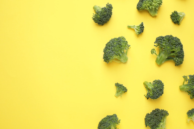 Fresh tasty broccoli on yellow background, flat lay. Space for text