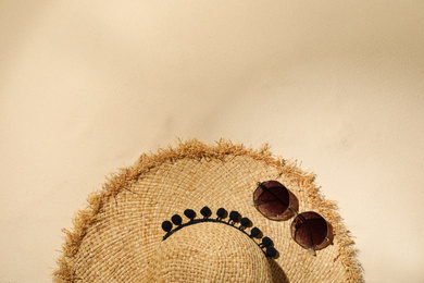 Photo of Flat lay composition with hat and sunglasses on sand, space for text. Beach objects