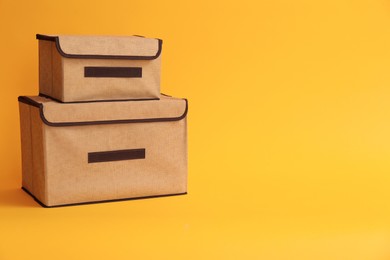 Two textile storage cases on yellow background. Space for text