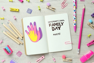 Photo of Happy Family Day. Flat lay composition with notebook and stationery on wooden table