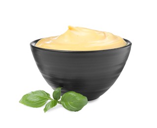 Tasty cheese sauce and basil on white background