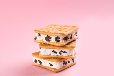 Sweet delicious ice cream cookie sandwiches on pink background