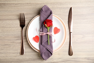 Beautiful place setting for romantic dinner on wooden table, flat lay. Valentine's day celebration