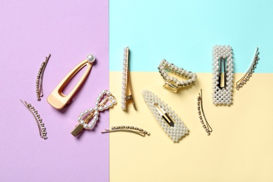 Photo of Stylish hair clips on color background, flat lay