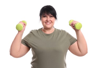 Photo of Happy overweight mature woman doing exercise with dumbbells on white background