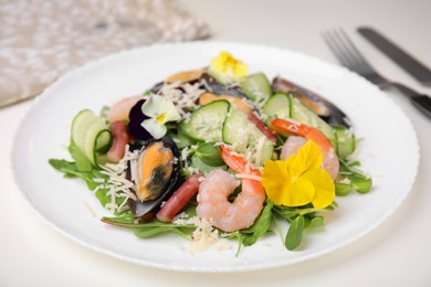 Photo of Plate of delicious salad with seafood on white table