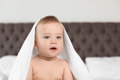 Photo of Adorable little baby with white towel indoors